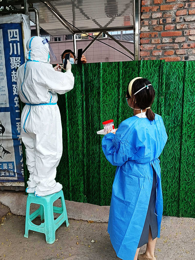 志愿者黄梅（右）在打围社区进行核酸采集工作.jpg